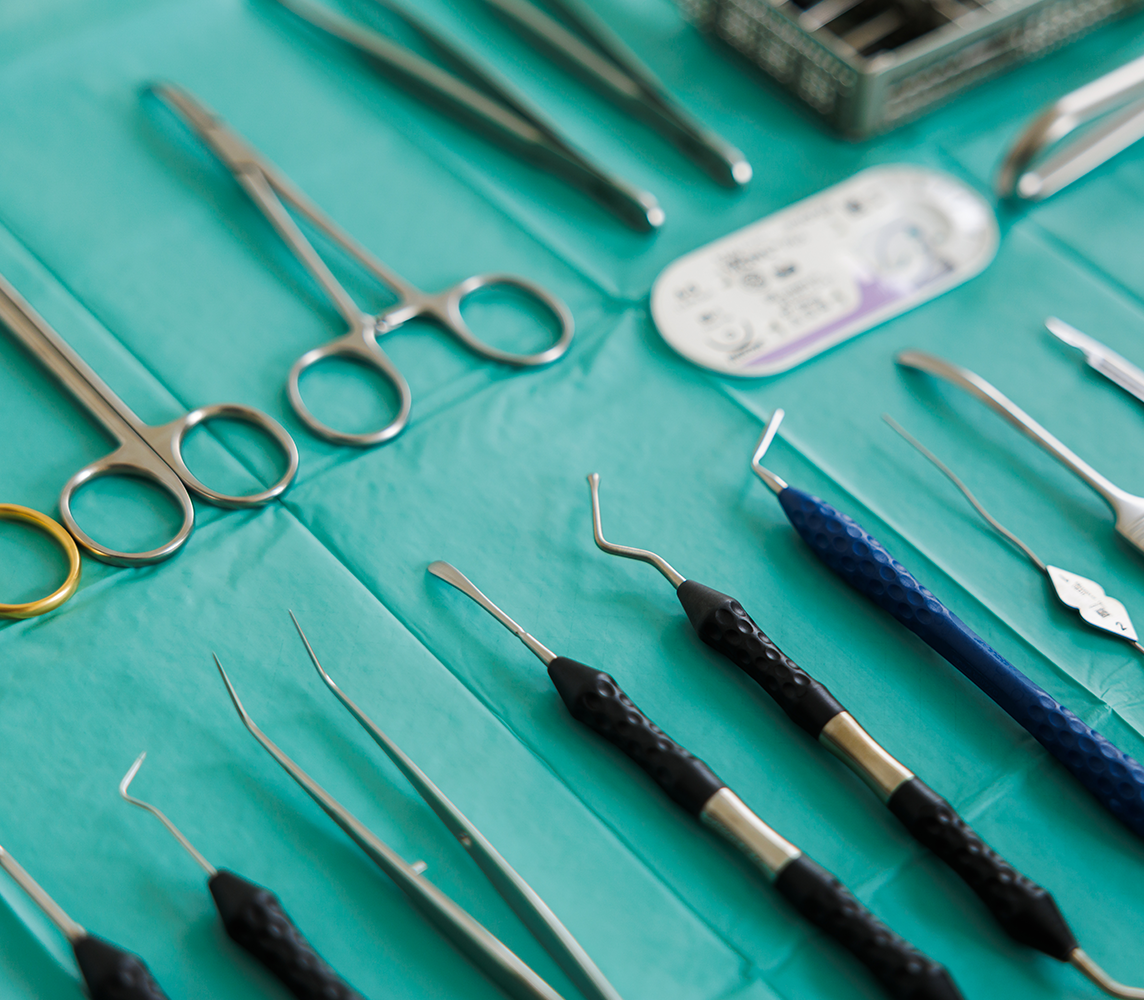 Sterile chirurgische Zahnarzt-Instrumente auf einem grünen Tuch aufgereiht
